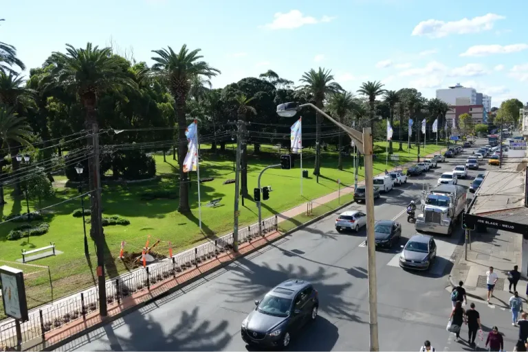 Aerial view of Burwood Road in Burwood with traffic, pedestrians, and lined with flags and palm trees